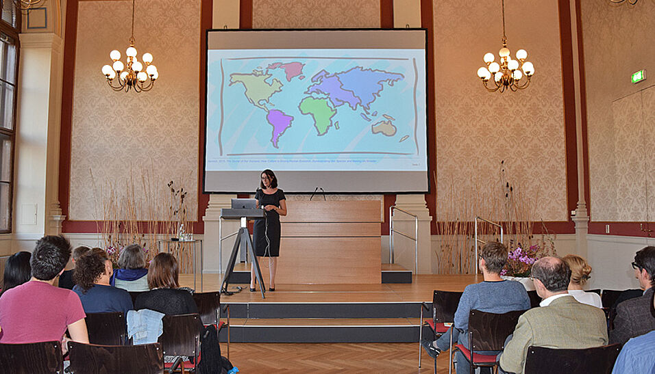 Blick von der hinteren Publikumsreihe im Kleinen Festsaal der Universität Wien auf die Bühne bei der Antritts-Vorlesung von Prof. Stefanie Höhl.