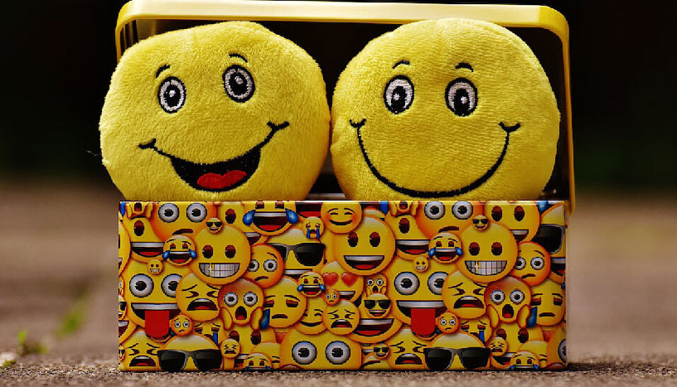 Smileys lachen aus einer Blechkiste.